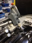 3D geprinte slanghouder (grijs) houdt een machineslang op zijn plaats tijdens het assembleren van een motorblok.